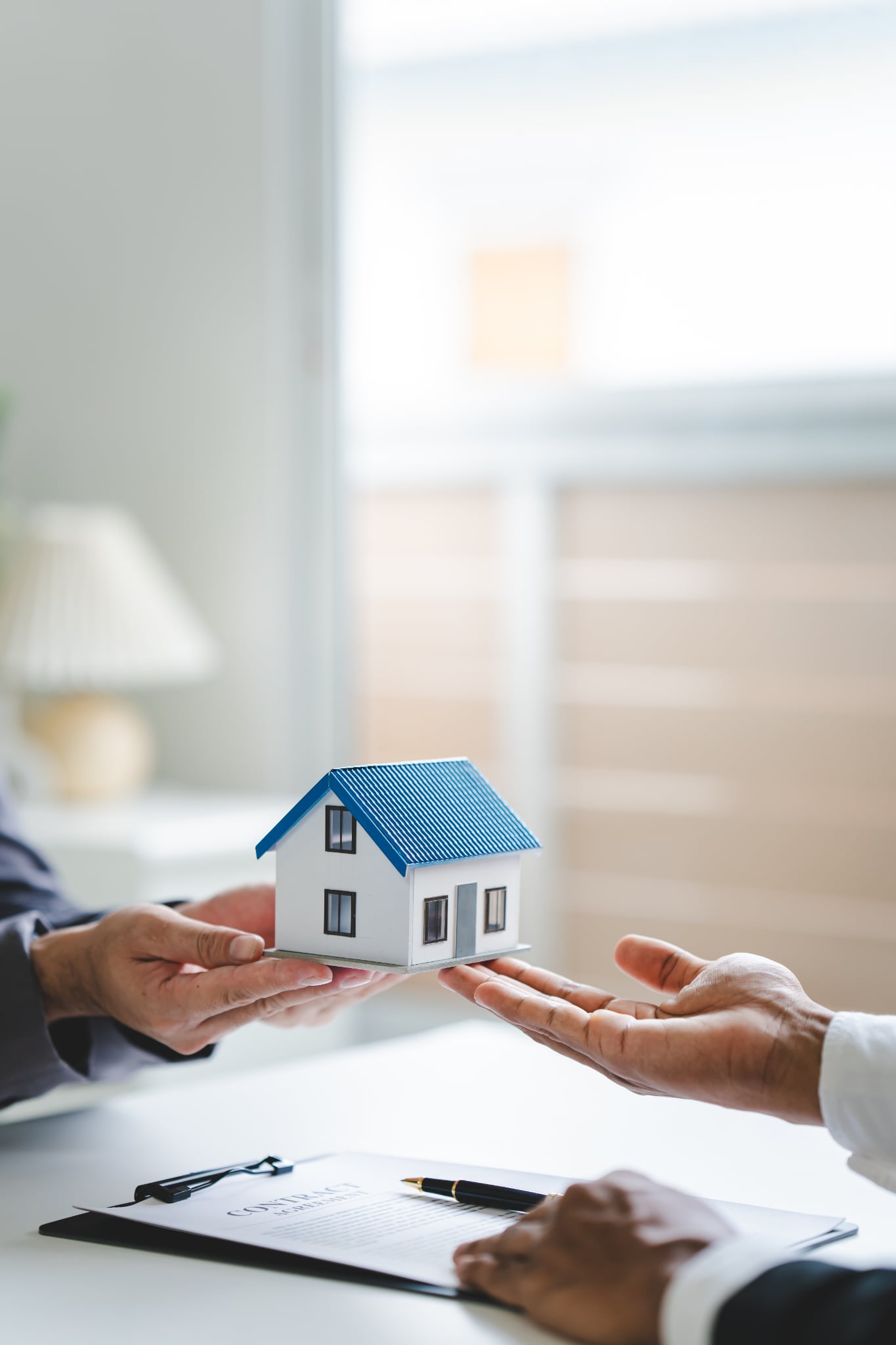 Two hands holding a small home model
